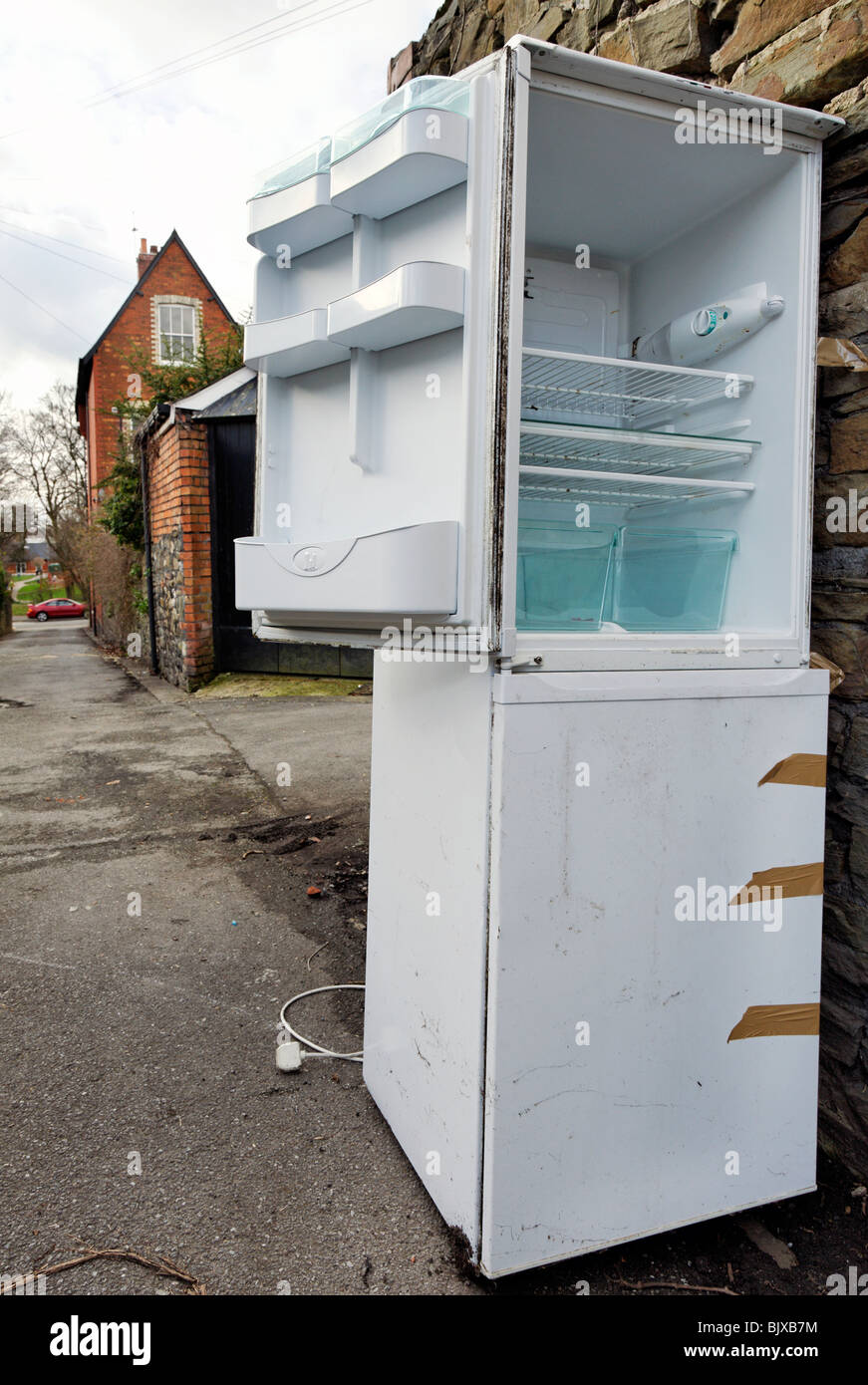 Fridge freezer dumped in urban back lane Stock Photo