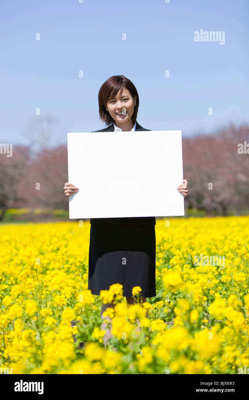 Young businesswoman holding blank placard Stock Photo