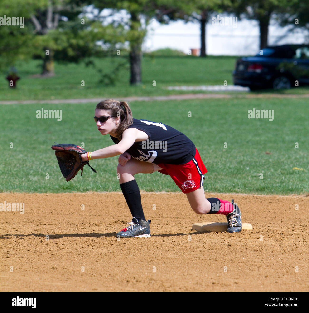 Girls high school softball game. A girl catching the ball Stock Photo