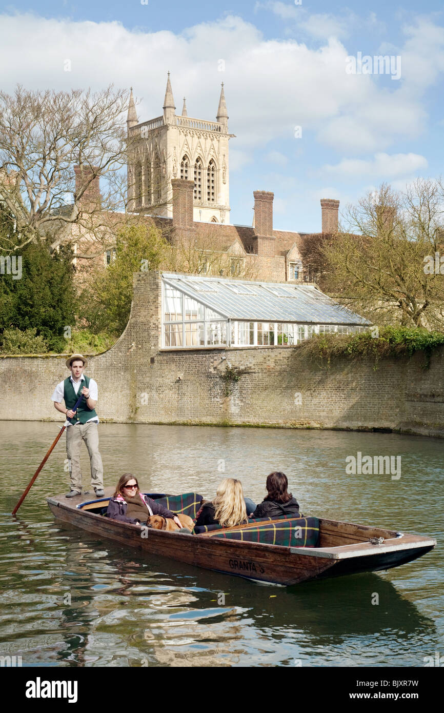 Punting Cambridge in traditional England style; Punting on the River cam in spring on the backs with St Johns College in the background, Cambridge UK Stock Photo