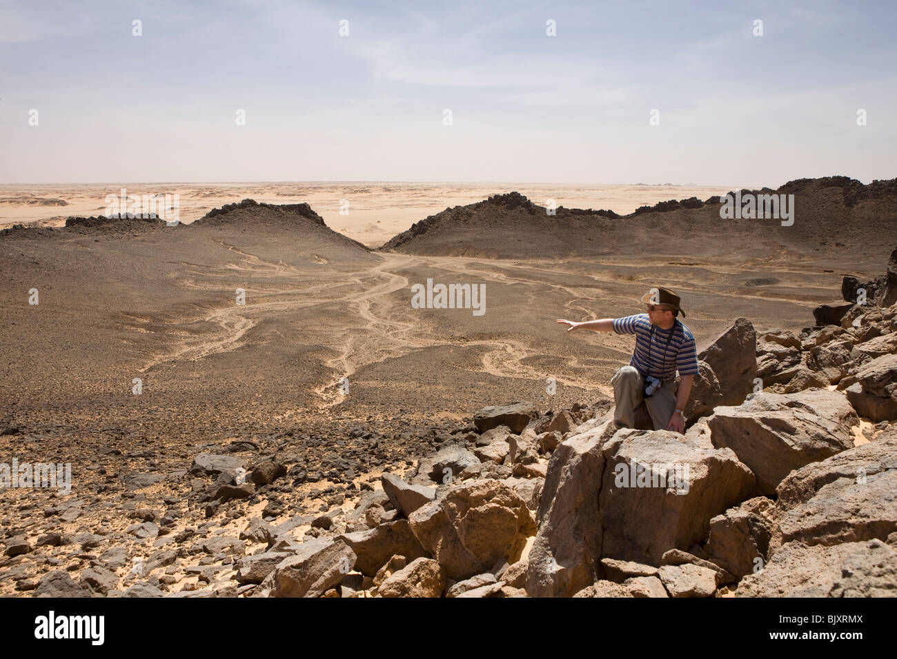 Geologist Colin Reader at the rim of one of the famous Clayton Craters, south of Gilf Kebir, Western Desert of Egypt Stock Photo