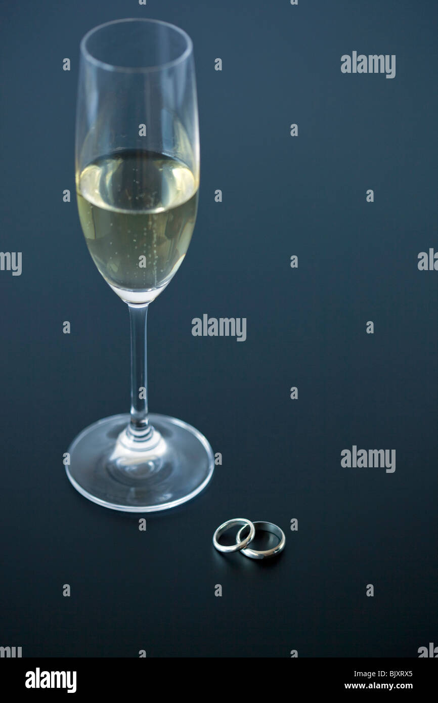A glass of champagne and wedding rings Stock Photo
