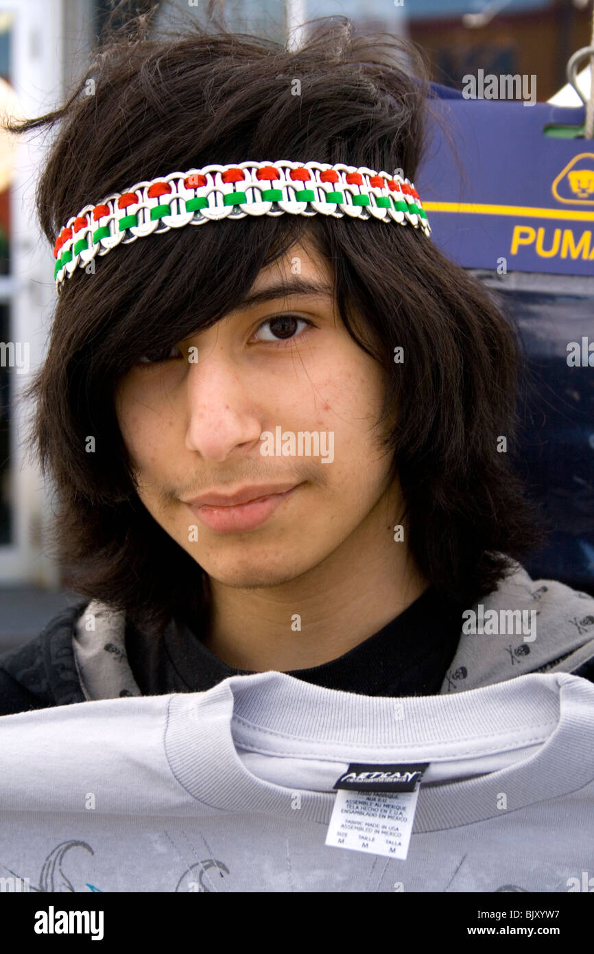 Teenage Hispanic shirt vendor age 17 holding a t-shirt for sale. Cinco de Mayo Fiesta St Paul Minnesota USA Stock Photo