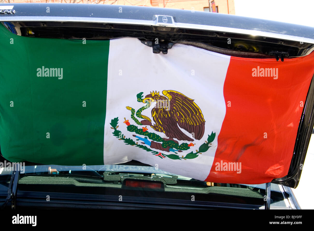 Mexican flag hanging from open trunk at the Lowrider custom car exhibit