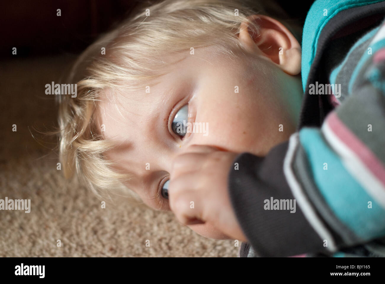 A tired baby boy sucking thumb Stock Photo