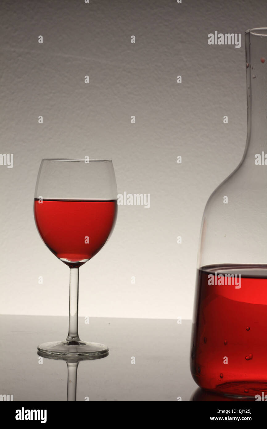 wine glass with red wine and bottle on table Stock Photo