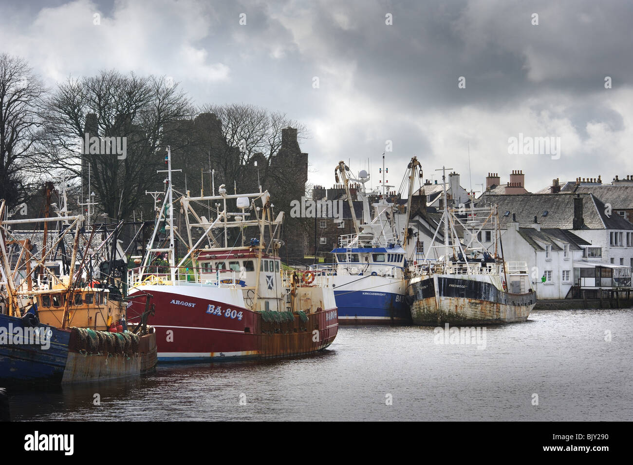 Scallop fishing boats in Kirkcudbright harbour berthed under the shadow of McLellan's castle Stock Photo