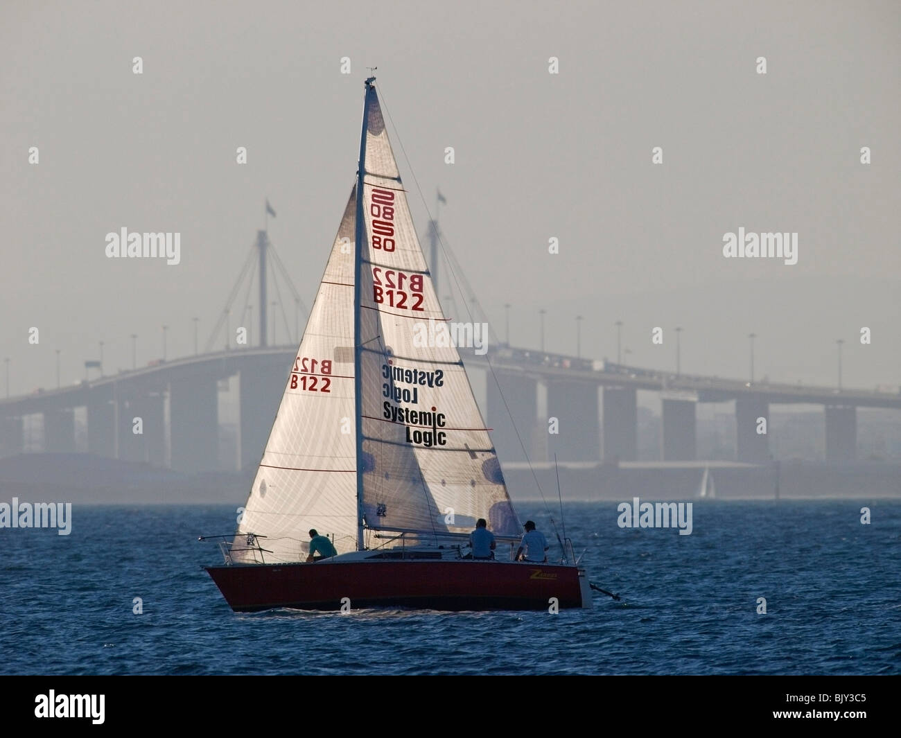 SAILING YACHT  ON PORT PHILLIP BAY WITH BRIDGE BEHIND MELBOURNE VICTORIA AUSTRALIA Stock Photo