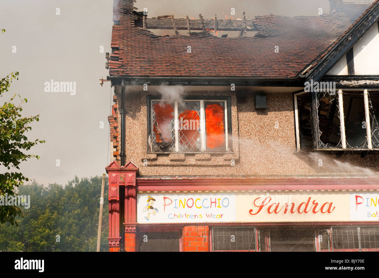 Flat on fire above shop flames issuing from window Stock Photo