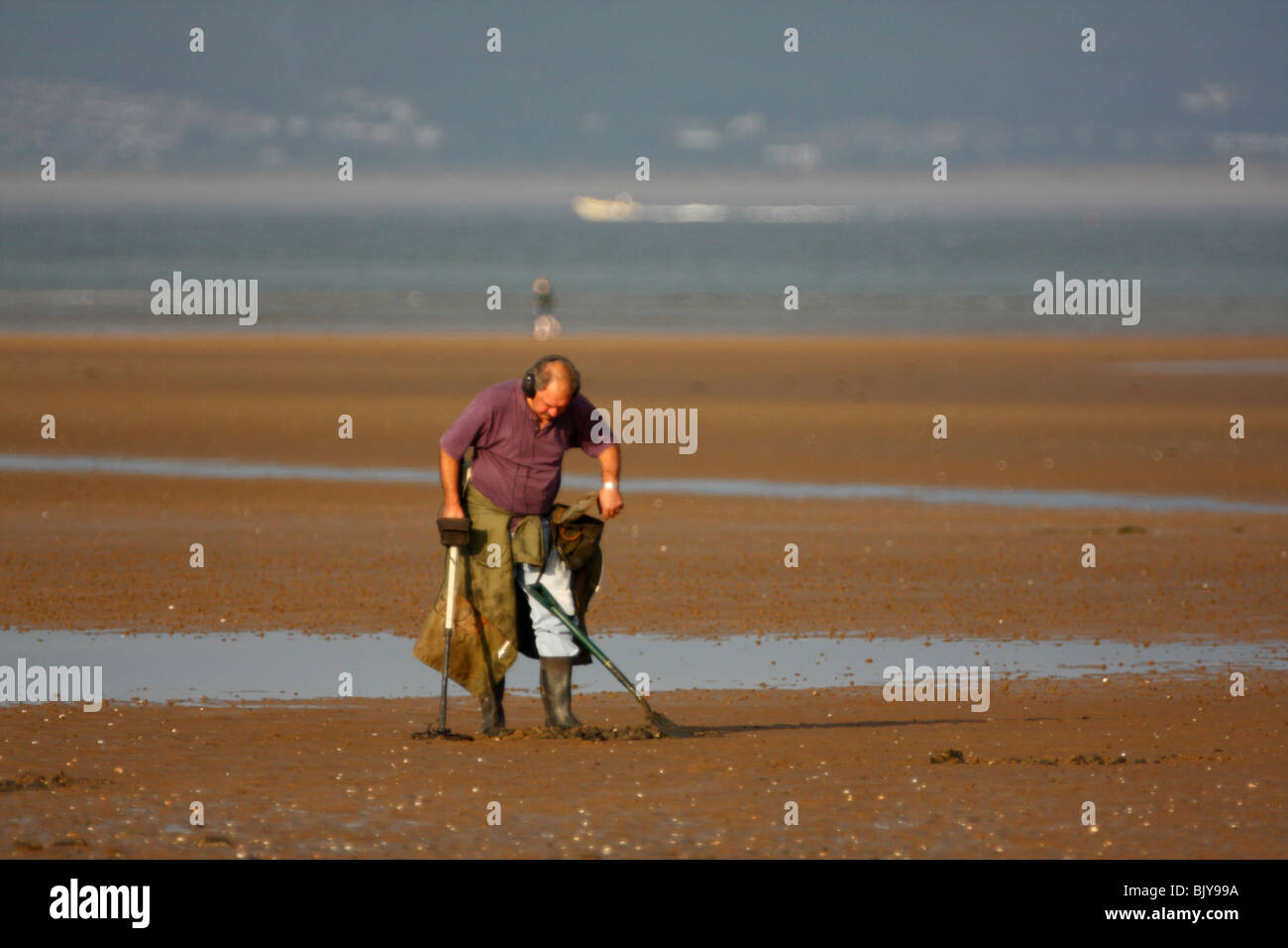 Man Using a Metal Detector on a Sandy Beach Stock Photo