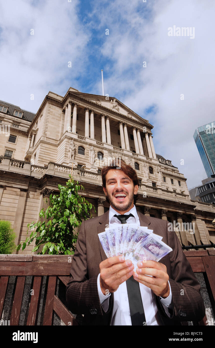 Vertical view of a business man holding twenty pound banknotes outside the Bank Of England in London England Stock Photo