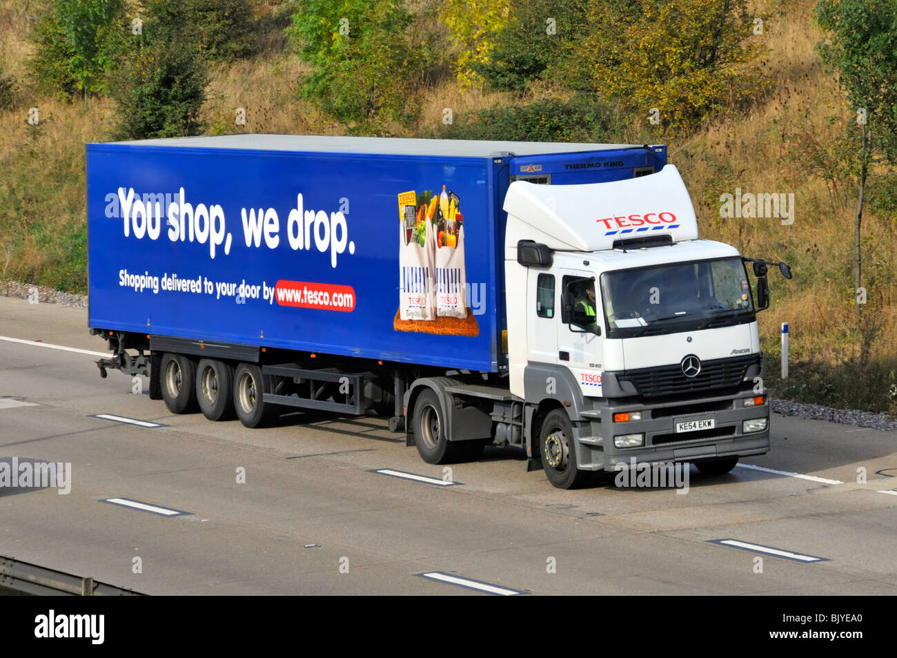 Hgv supermarket food supply chain store grocery delivery lorry truck with trailer advertising Tesco food business driving on UK motorway Stock Photo