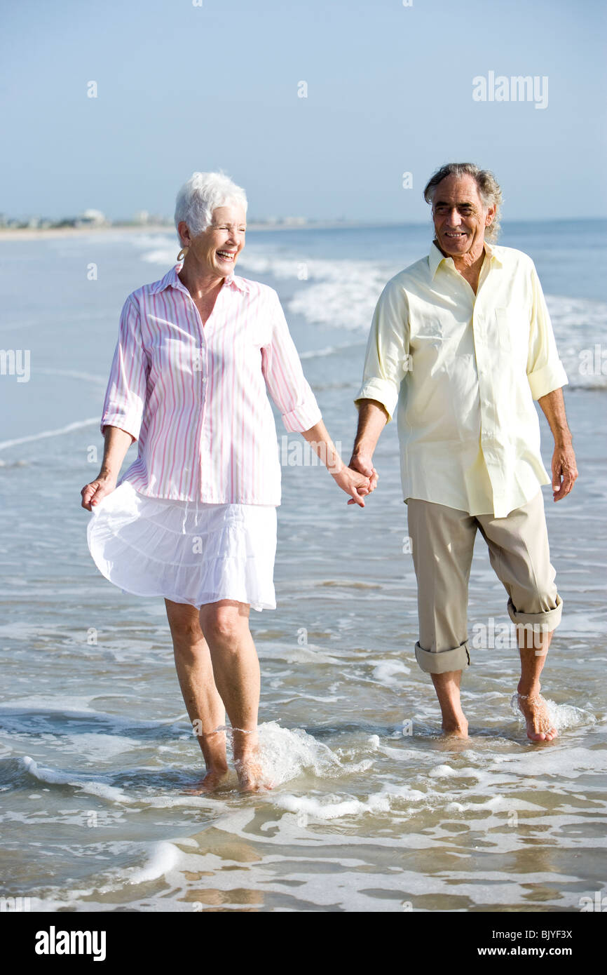 Senior couple strolling on the beach holding hands Stock Photo - Alamy