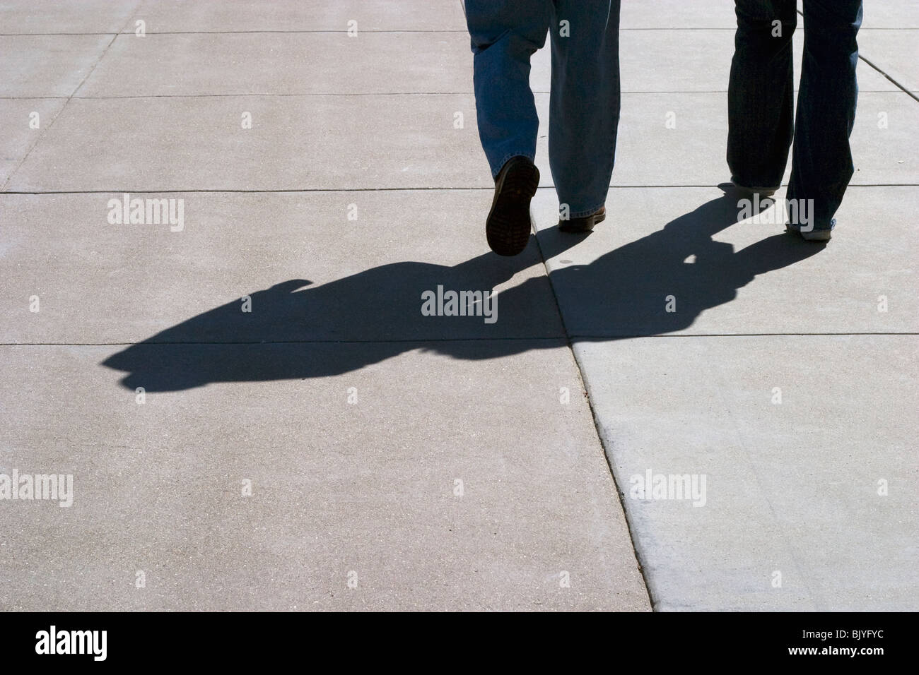 dark shadow of man and son walking along the sidewalk Stock Photo - Alamy