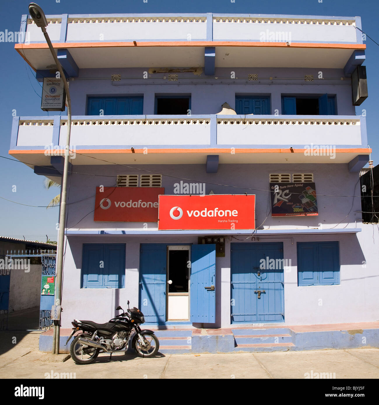 A motorbike stands outside of a Vodafone shop Diu, Inda. Stock Photo