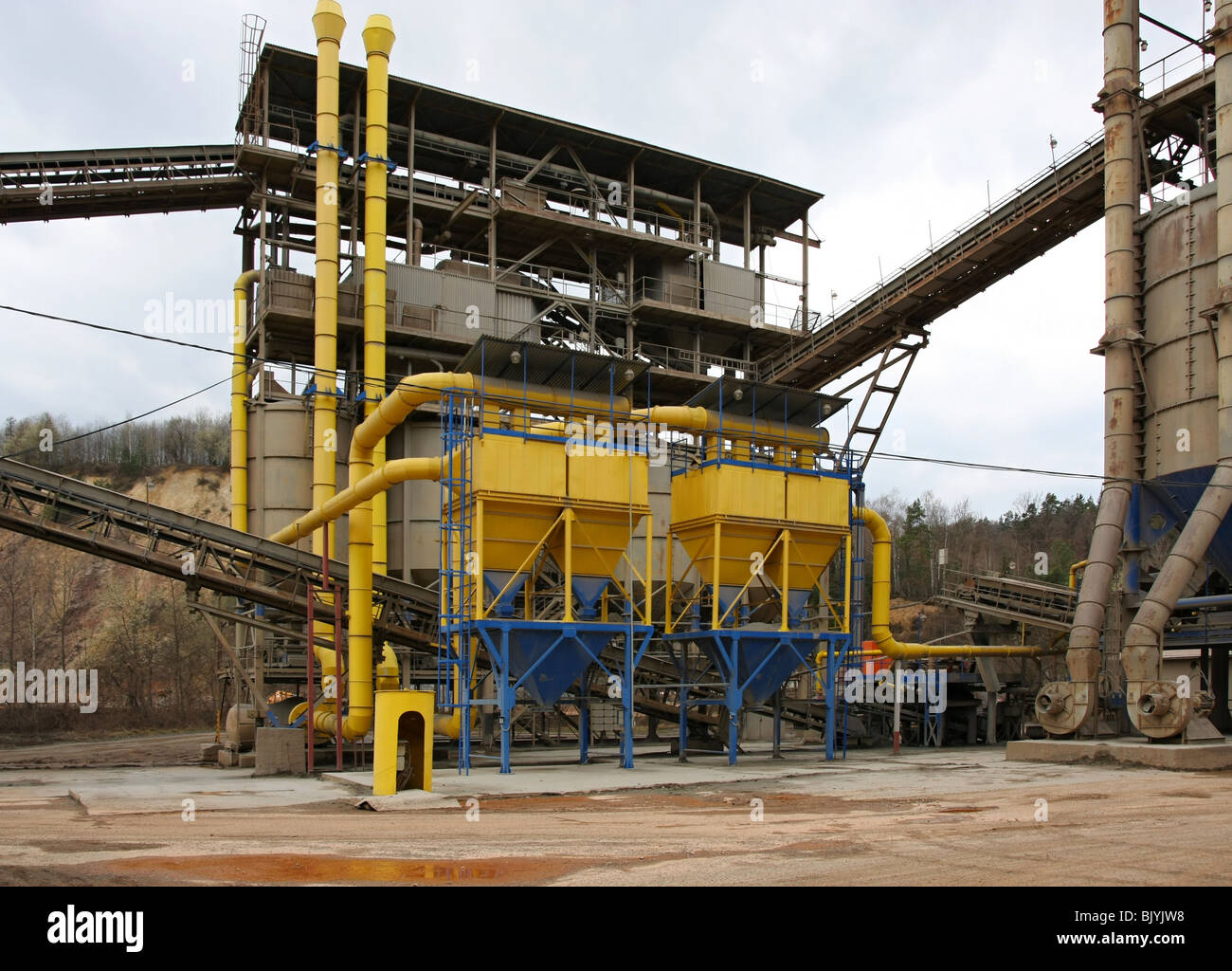 Stone quarry with silos, conveyor belts and piles of stones Stock Photo