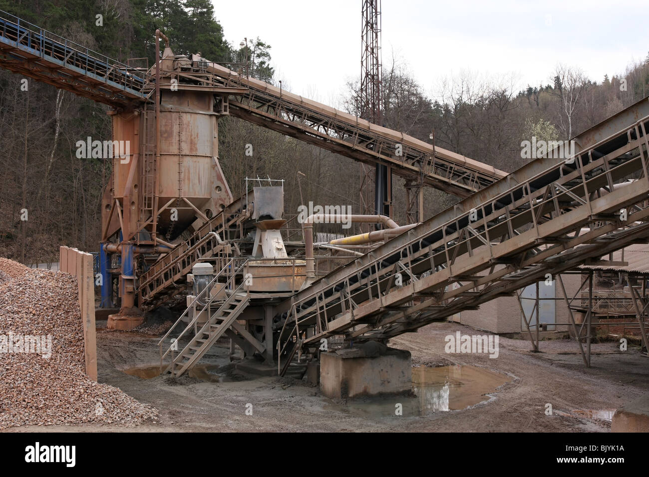 Stone quarry with silos, conveyor belts and piles of stones Stock Photo
