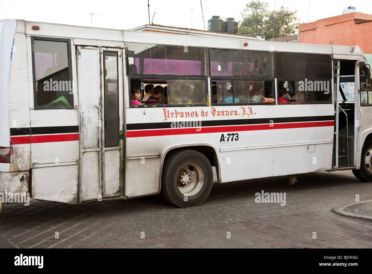 venerable old reliable Mercedes bus stuck in traffic with resigned passengers blocks intersection in Oaxaca City Mexico Stock Photo