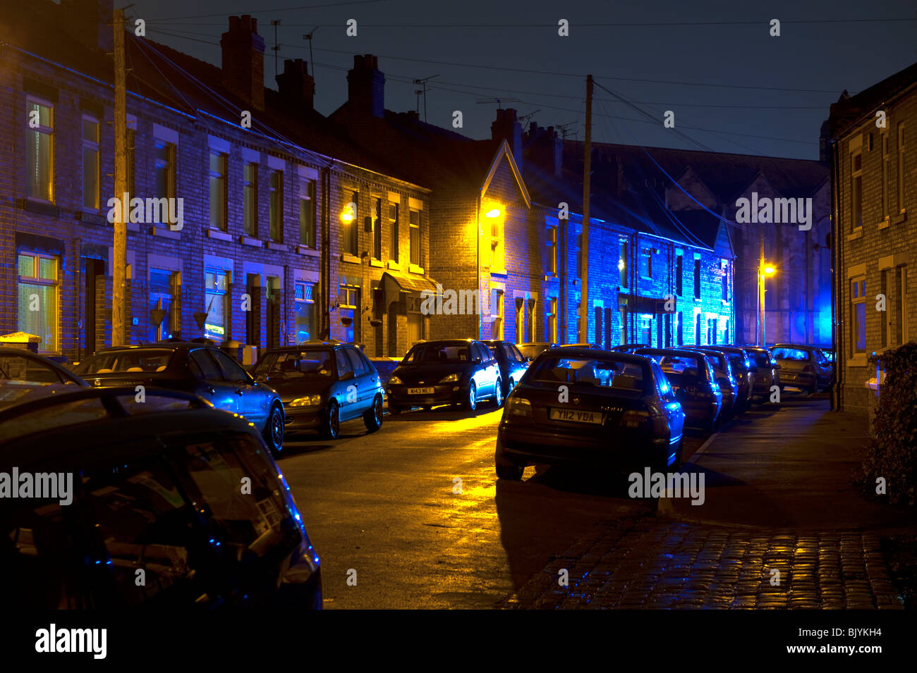 Terraced houses lit up by eerie blue light at night Stock Photo