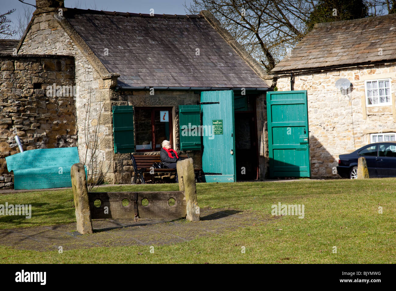 Tourist information centre and village stocks in the village of Eyam, Derbyshire, Peak District, England, UK. Stock Photo