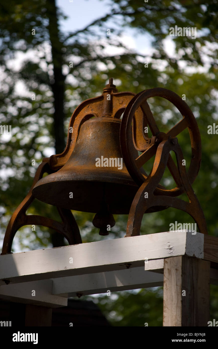 Rusting Victorian-Era church bell on stand located behind the Hutchinson House Museum in Waupaca, Wisconsin. Stock Photo