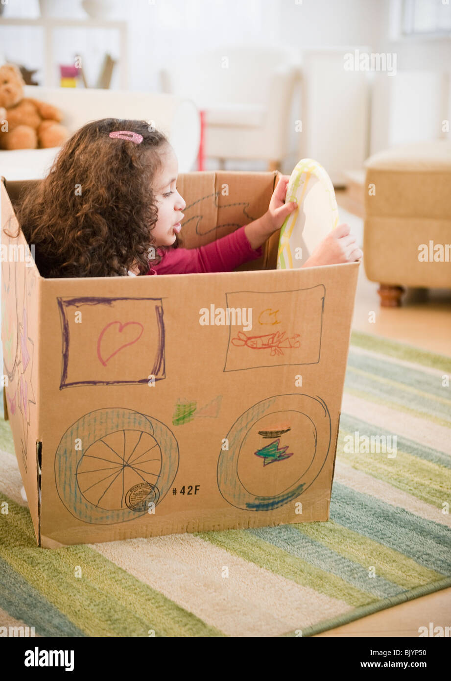 Hispanic girl playing in cardboard car Stock Photo - Alamy, image size:921x1390