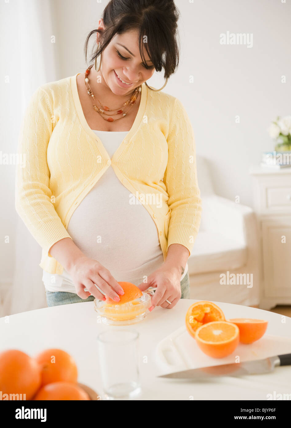 Pregnant Hispanic woman squeezing oranges Stock Photo Alamy