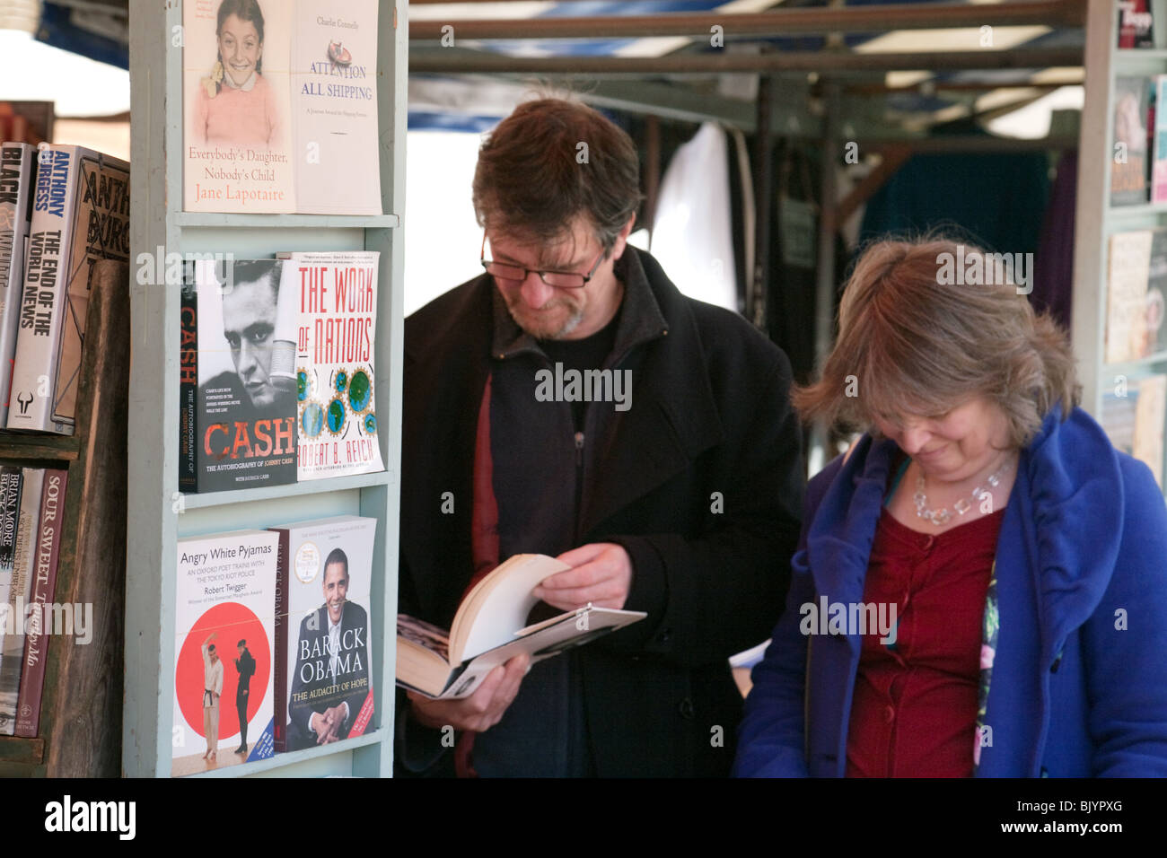 A couple shopping for second-hand books, the market, Market Square, Cambridge, UK Stock Photo