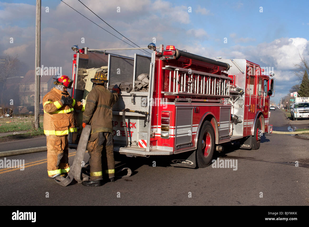 Firefighters prepare to stretch fire hose at 2nd Alarm Fire Detroit Michigan USA by Dembinsky Photo Assoc Stock Photo