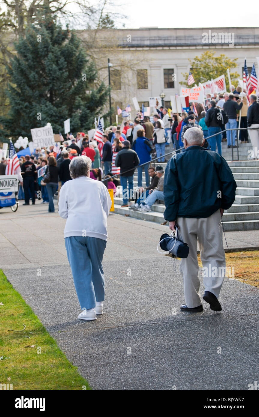 A senior couple walks toward a group gathering on the capitol steps to ...
