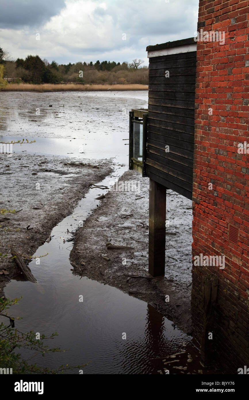stilt house extension over the Beaulieu River and mud flats with rivulet and red mrick wall Stock Photo