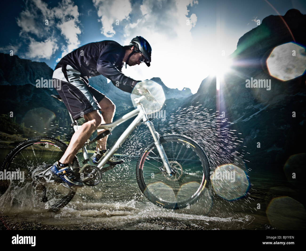 Male mountain biker riding through water Stock Photo Alamy