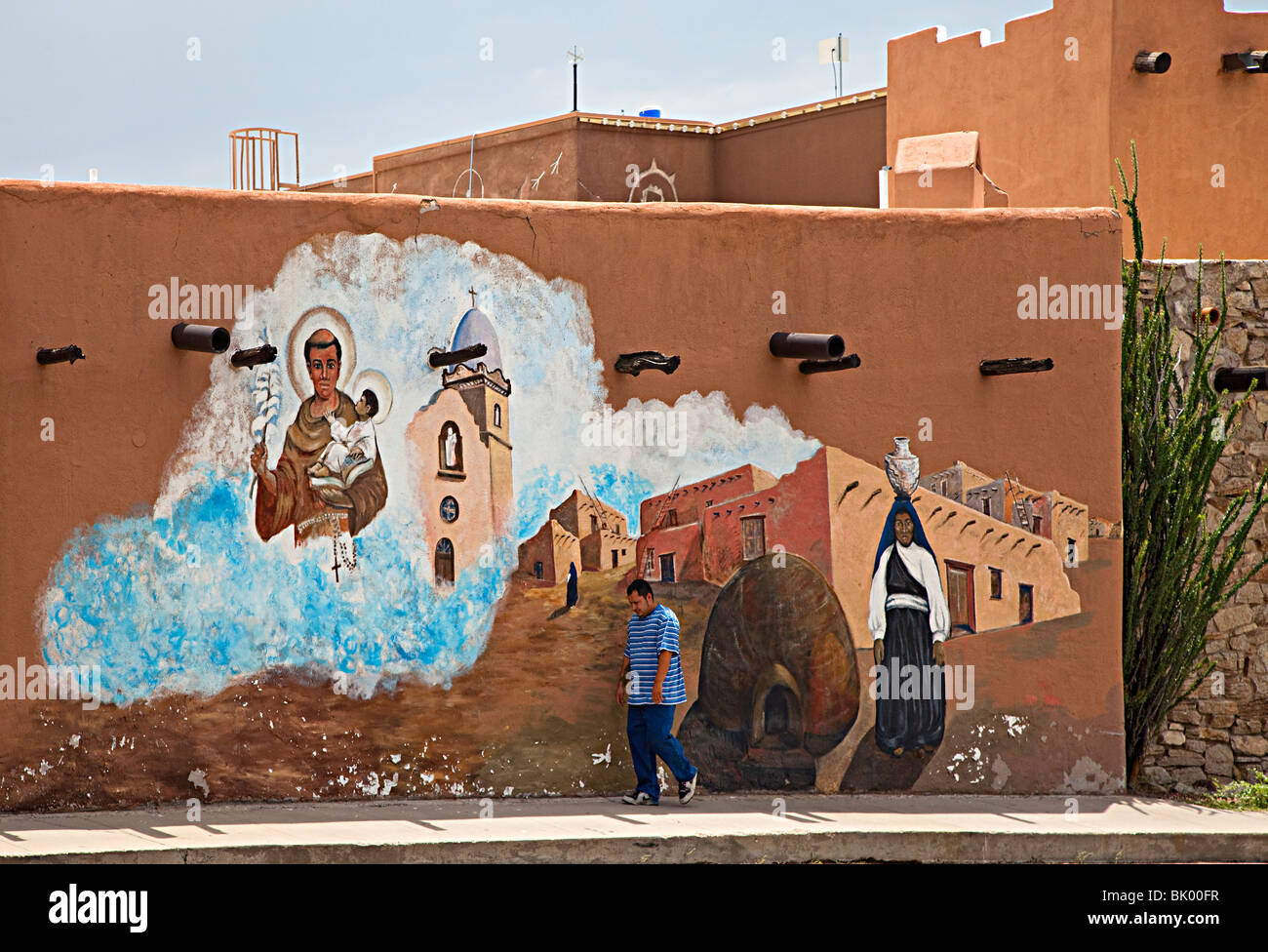 Man walking past mural of Mission Ysleta El Paso Texas USA Stock Photo
