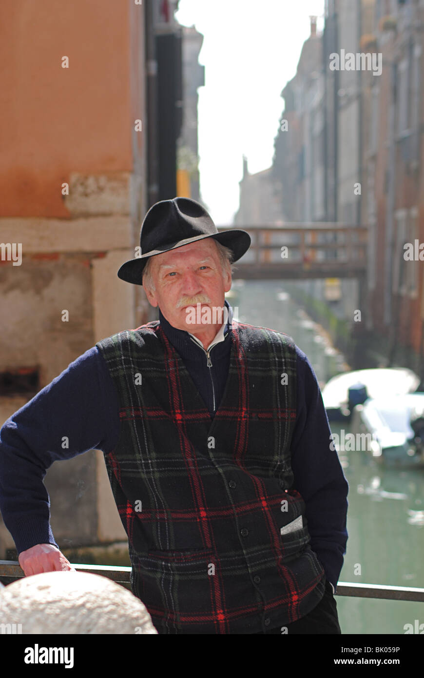 A man stands on a bridge in Venice, Italy Stock Photo