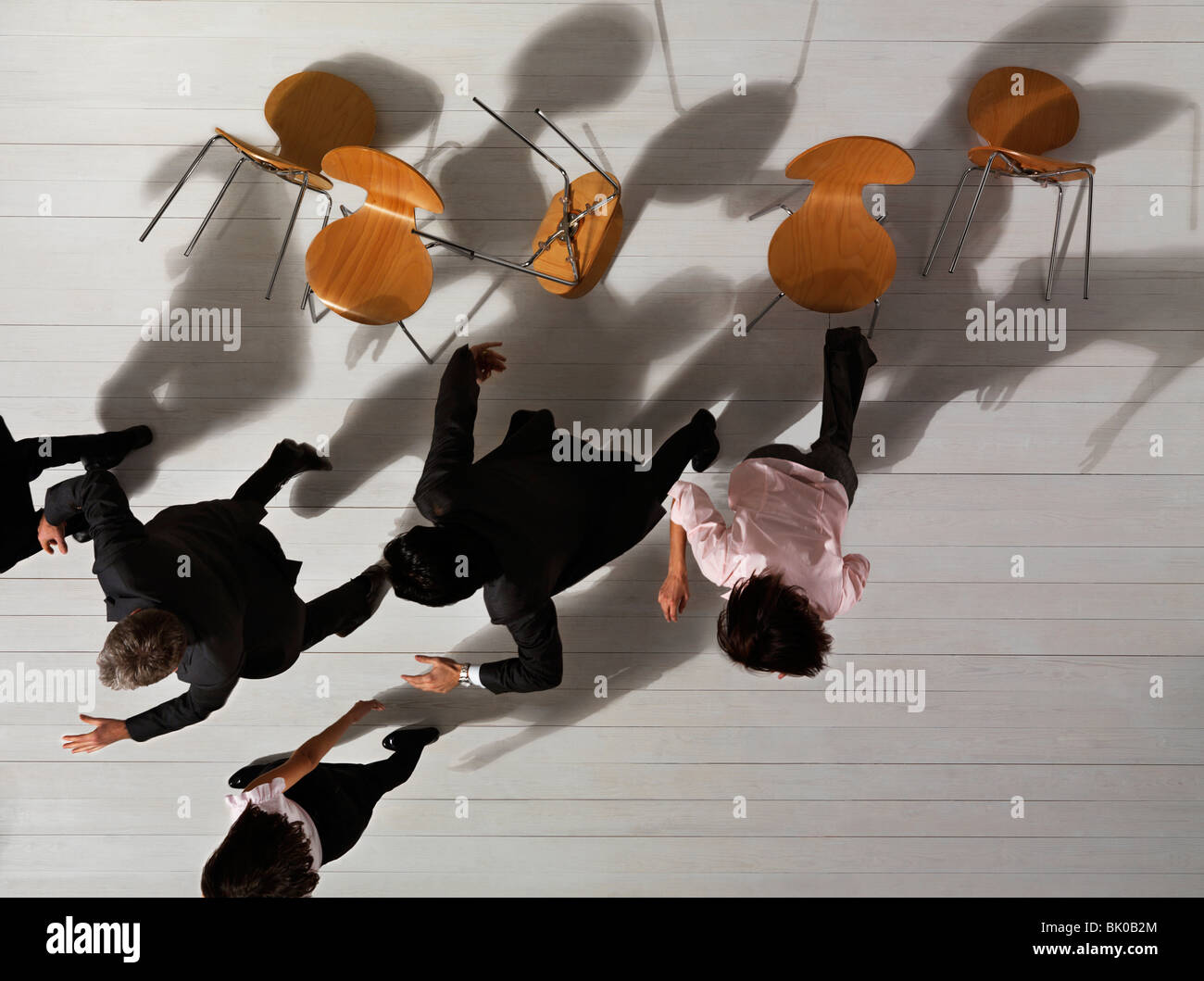 Business people knocking over chairs hires stock photography and