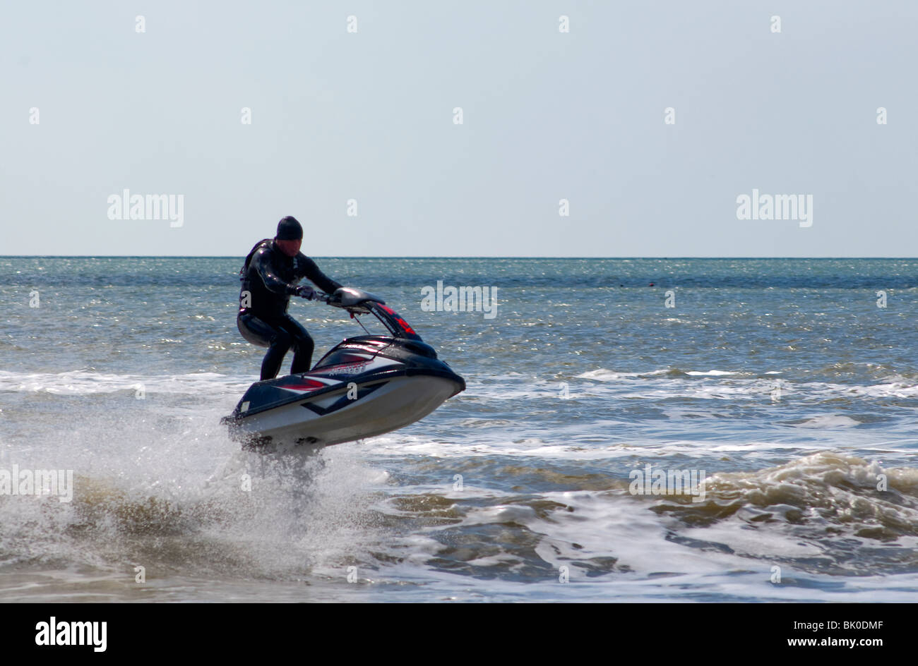 Jet skiing off the beach in Bournemouth, jumping the surf and having fun. Stock Photo