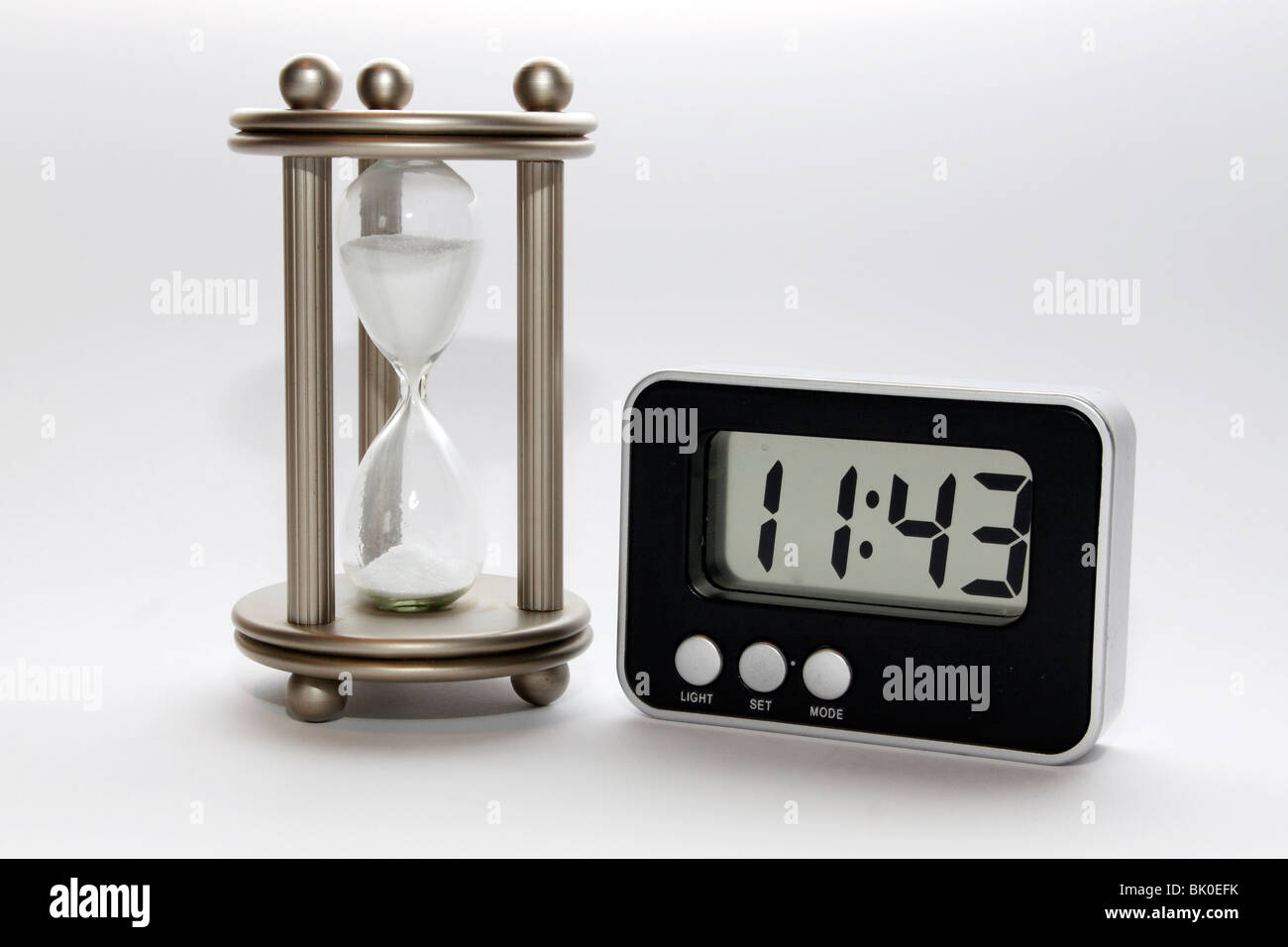 A hourglass and a digital clock Stock Photo
