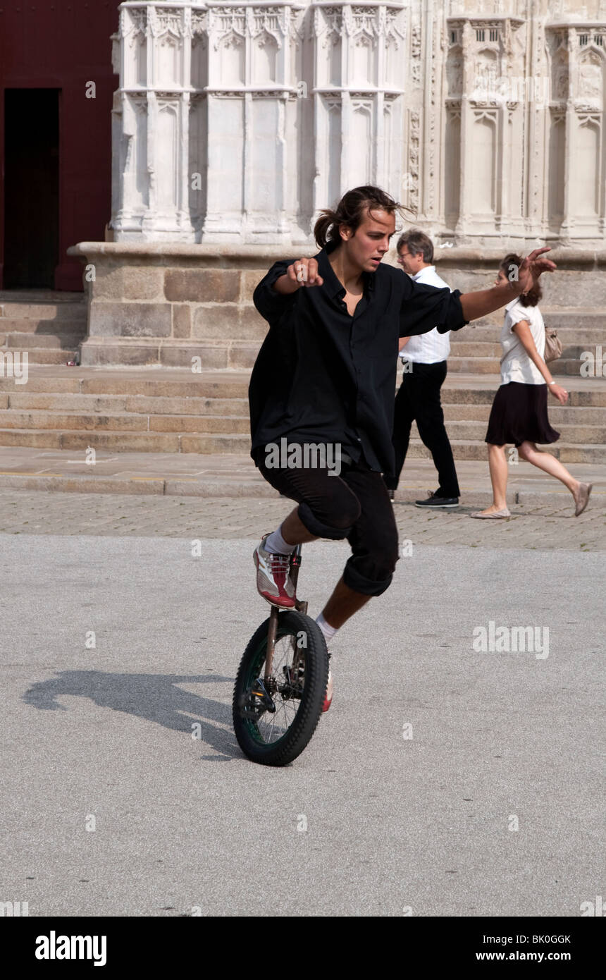 Man riding a unicycle in front of the Cathedral of St. Peter and St. Paul, Nantes Stock Photo