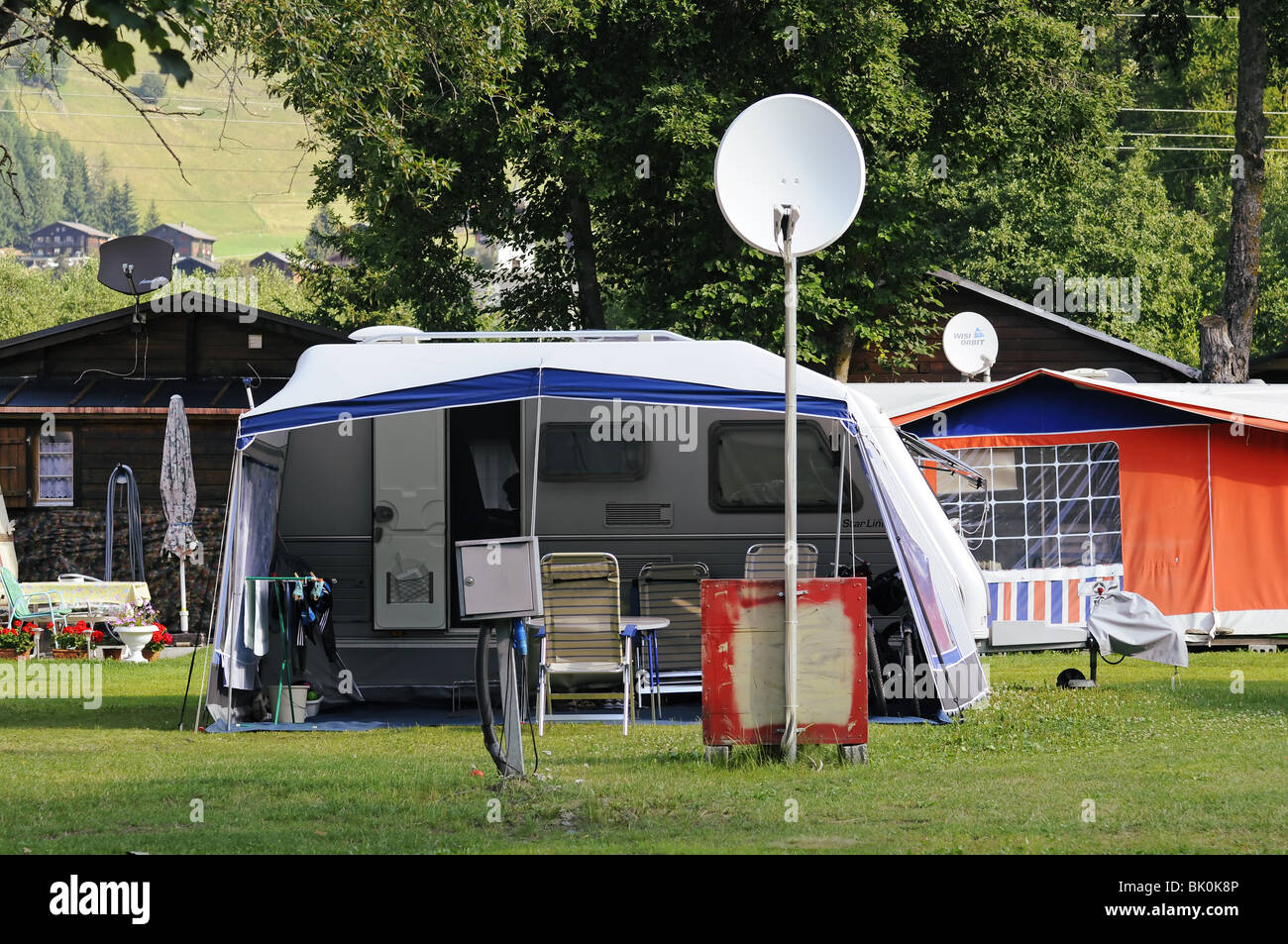 Tents and mobile home and sat dish in camping Stock Photo