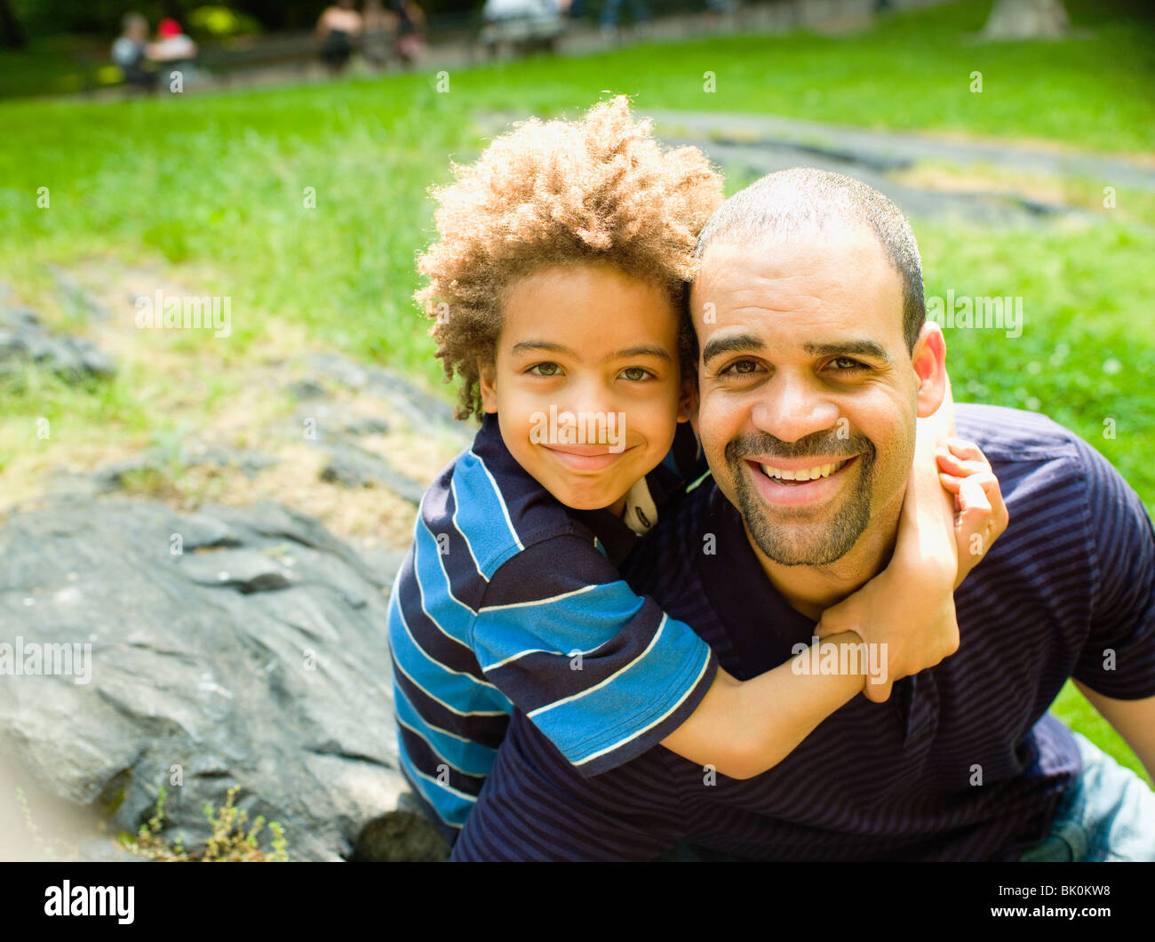 Boy hugging father outdoors Stock Photo