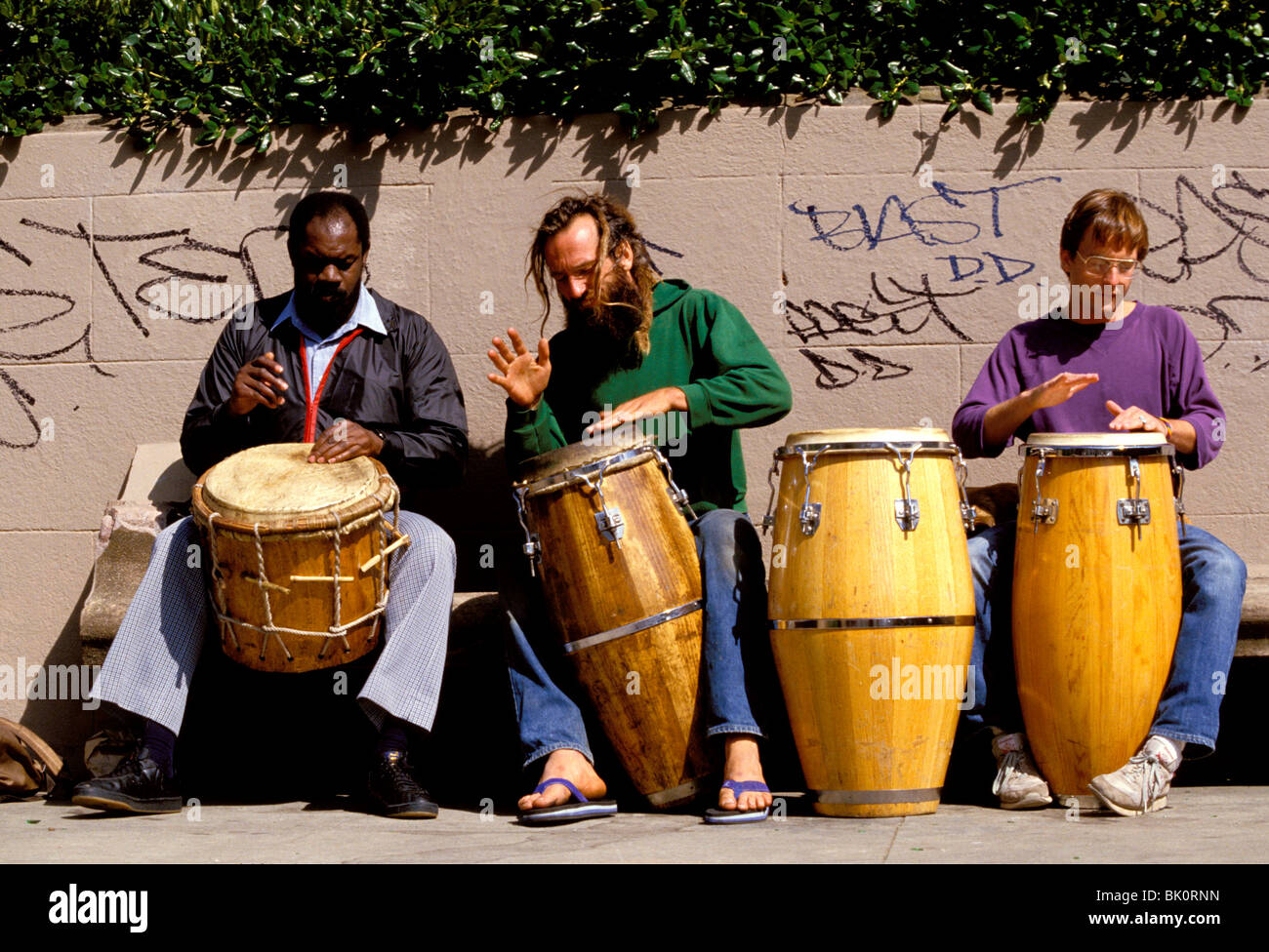 Three hippy drummers busking in the street at Haight Ashbury, San Francisco, California, USA. Stock Photo