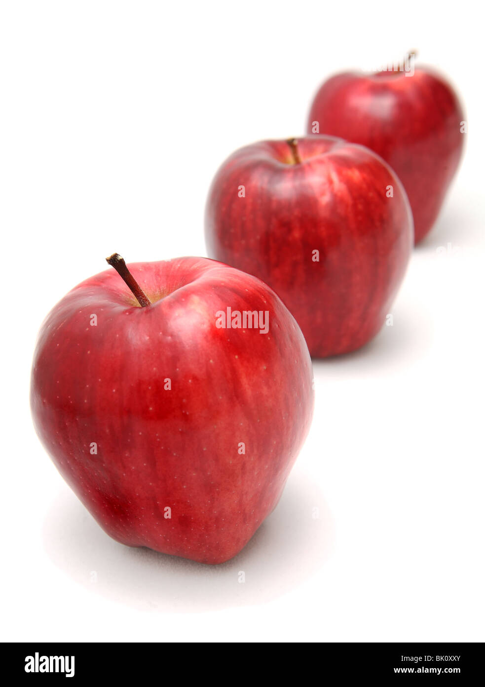 Three red delicious apples in a line on white background Stock Photo