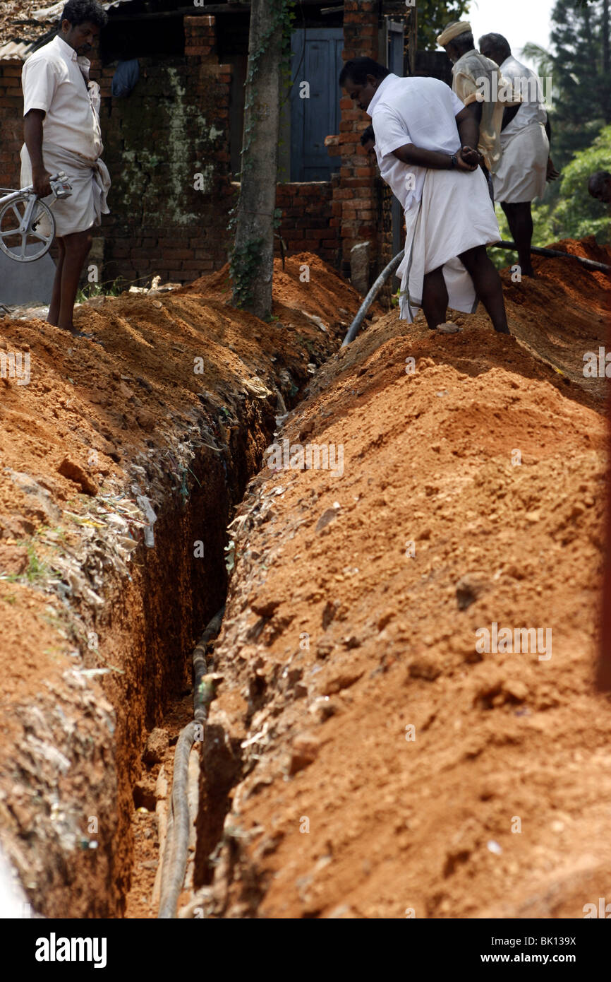 Men at work digging a trench for laying telephone cables in
