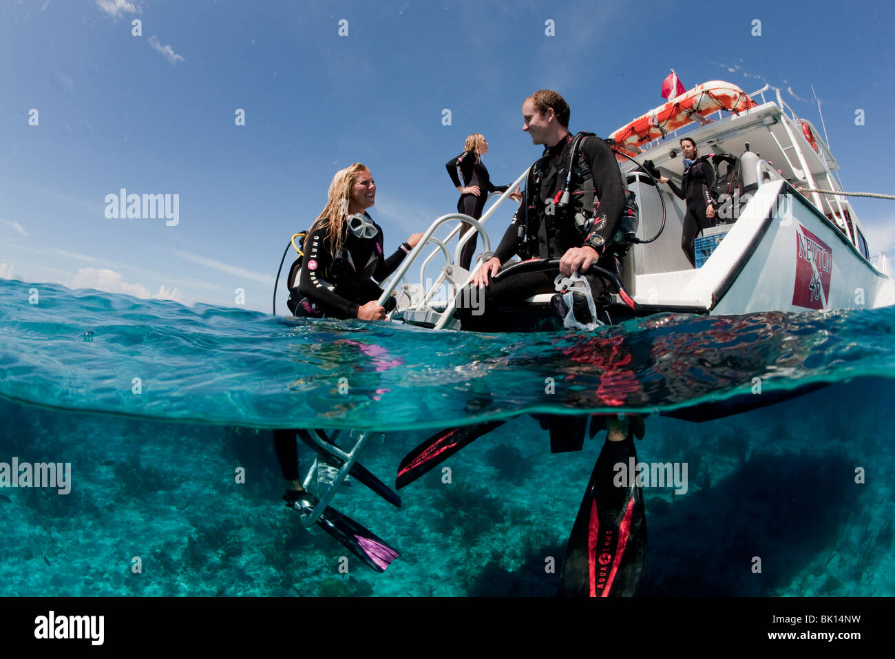 Scuba divers relax at the dive platform of a boat Stock Photo