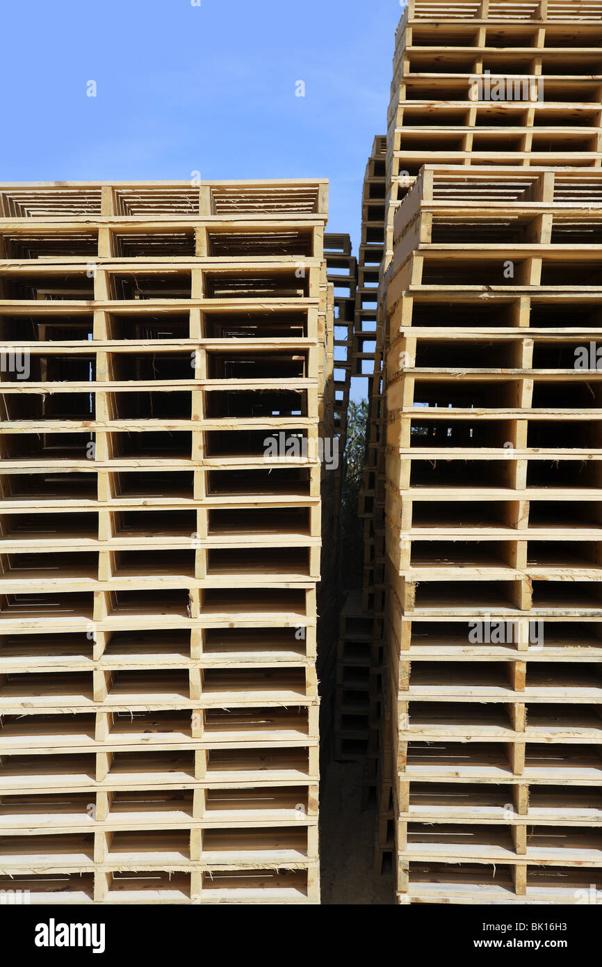 wooden pallets stacked blue sky industry storage transport Stock Photo