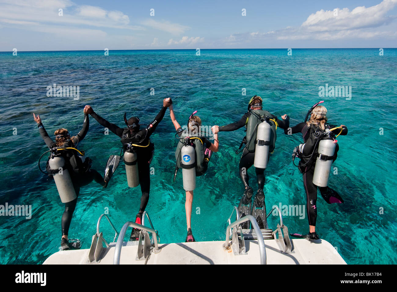 Scuba divers enter water from boat via giant stride entry Stock Photo