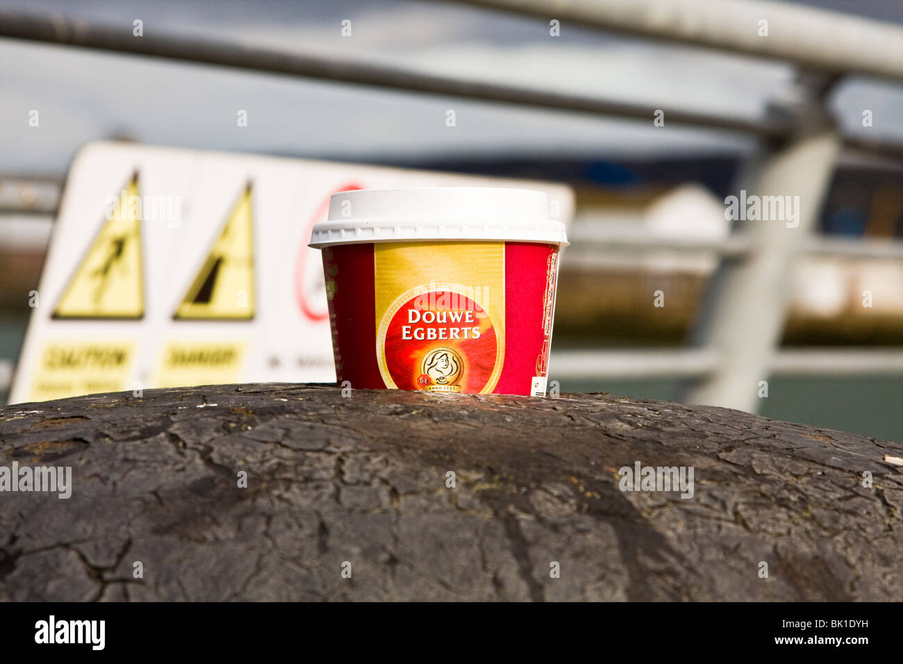 Douwe Egberts coffee cup on bollard with industrial background Stock Photo