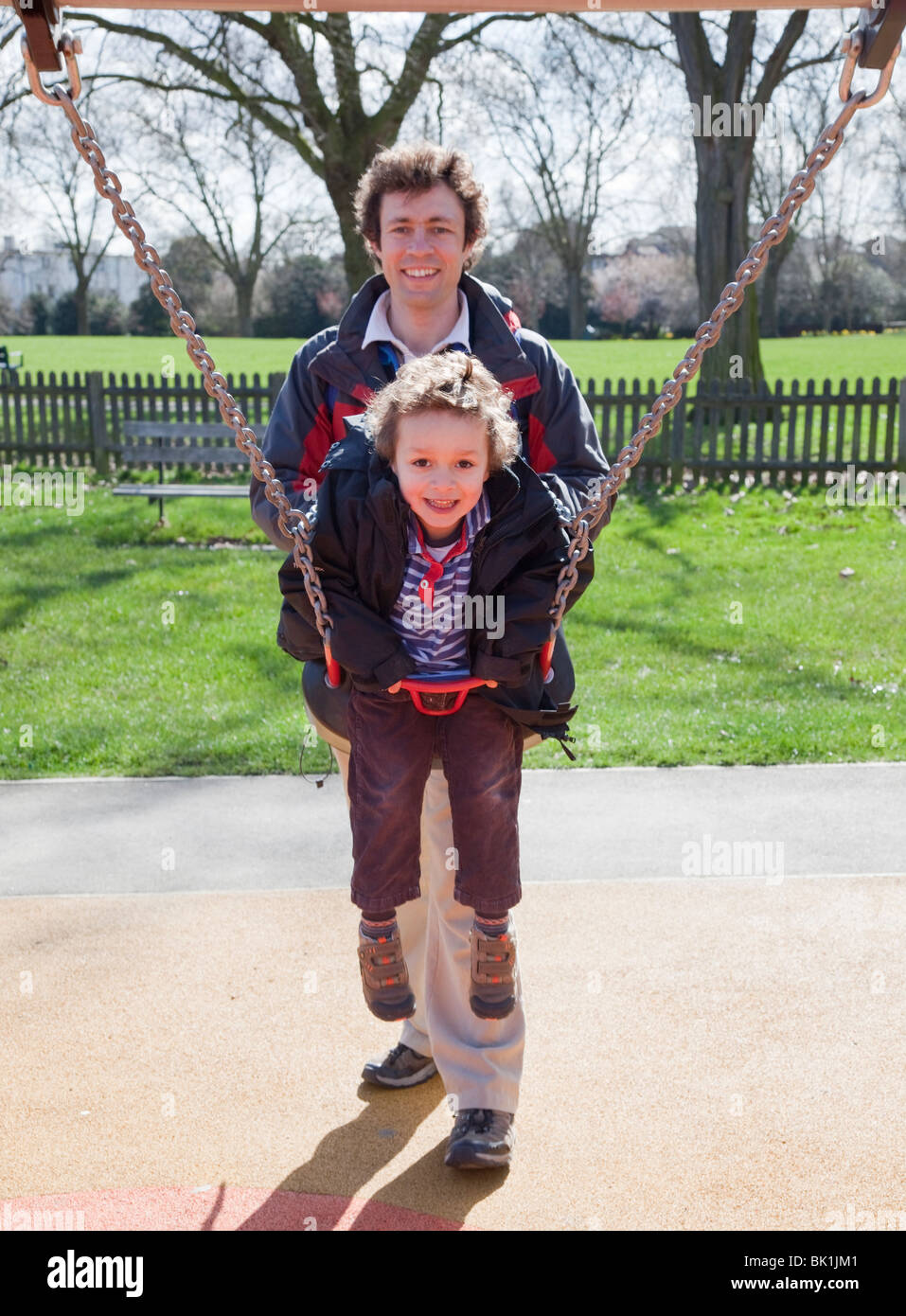 Father and son playing on the swings in a London Park Stock Photo - Alamy