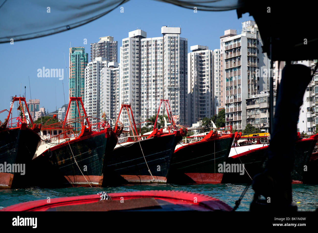 High rise buildings and fishing fleet in Hong Kong harbour. Stock Photo
