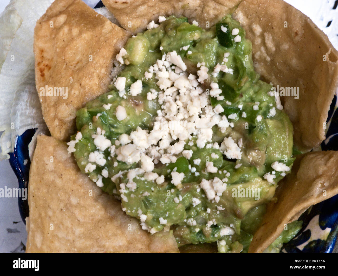 Guacamole appetizer sprinkled with fresh white cheese & ringed with